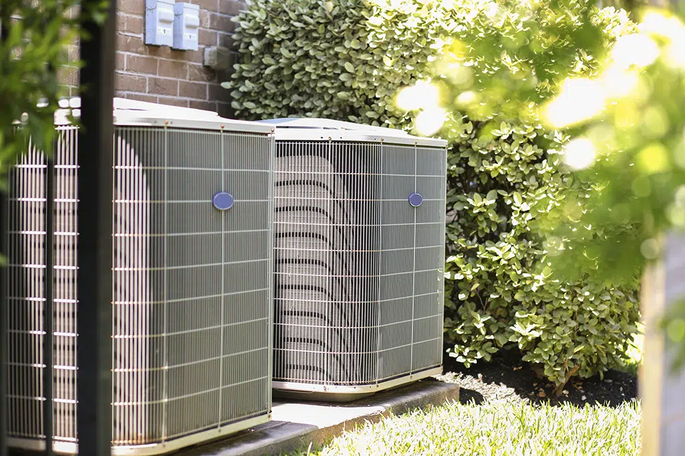 Two outdoor AC condenser units beside a home — air conditioning installation Lake Gaston Area