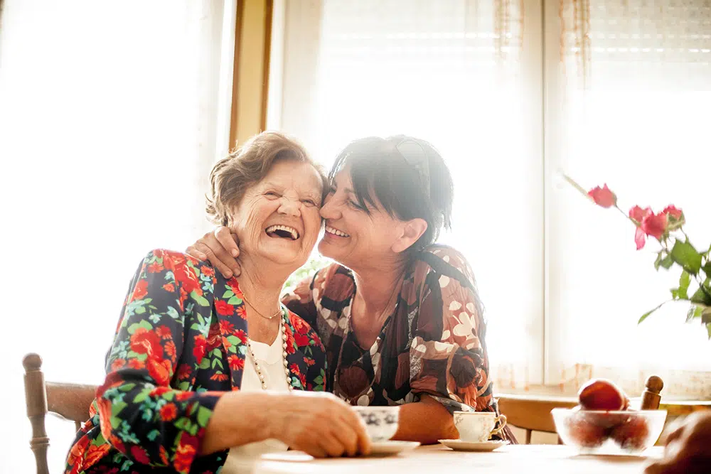 Two women laughing at home — satisfied Lake Gaston Area plumbing and HVAC customers