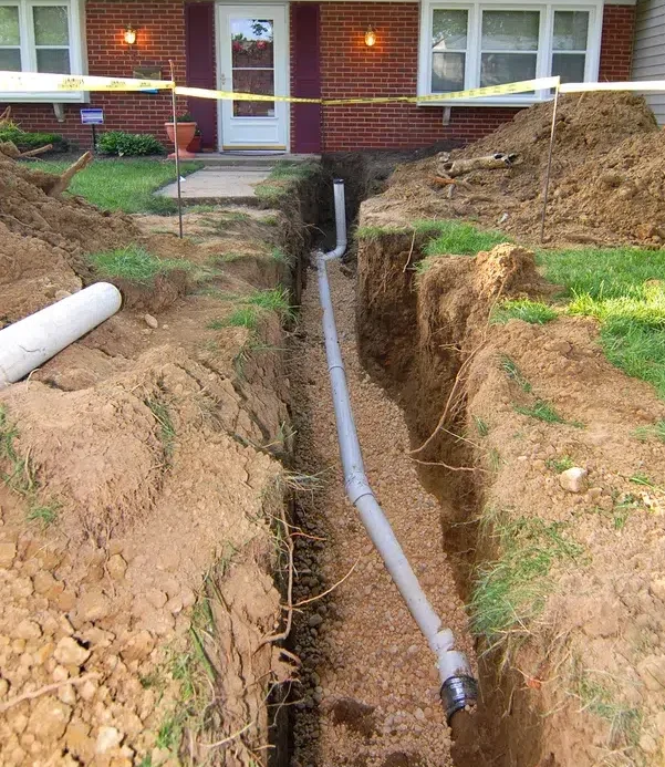 Trench dug in front yard for new sewer line pipe — sewer line replacement near Lake Gaston Area